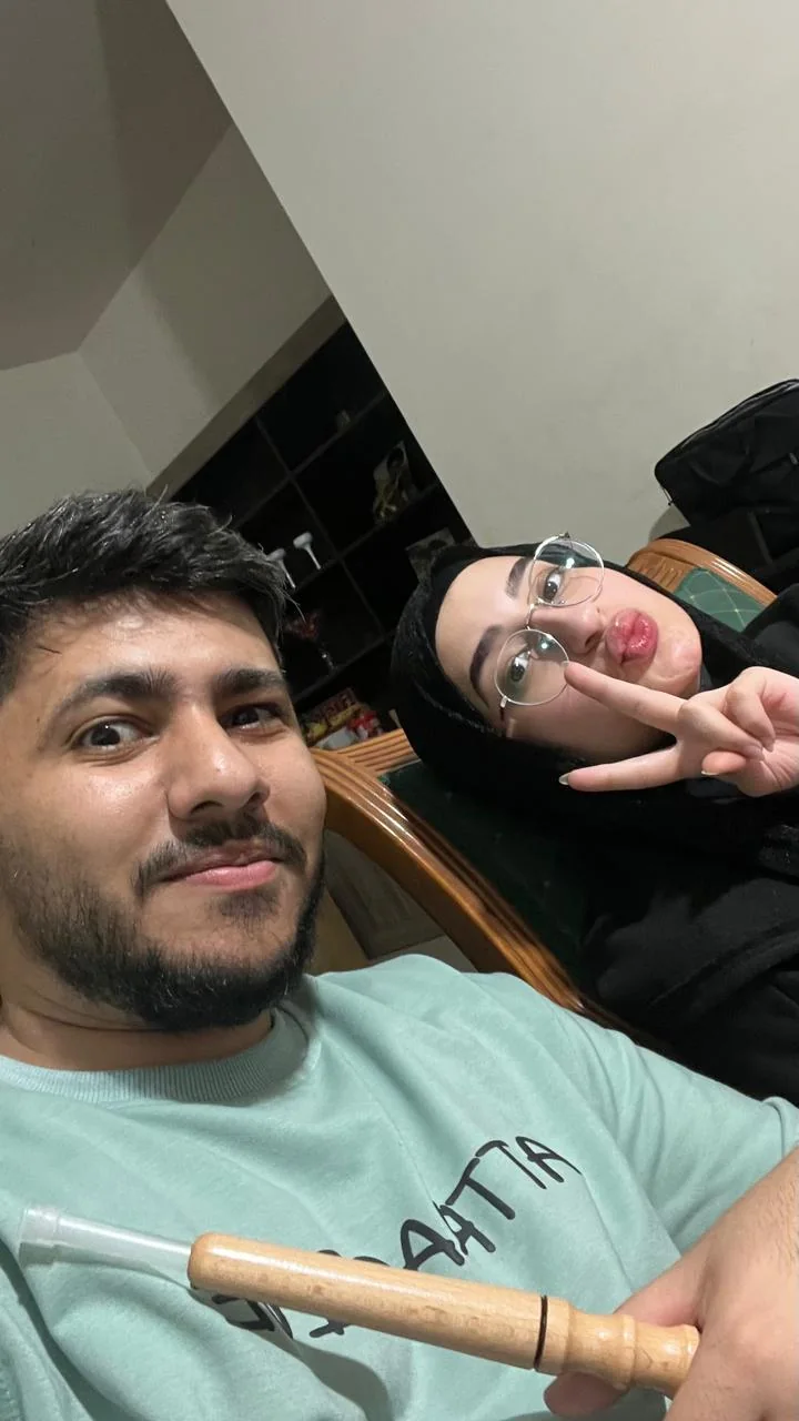 A selfie where Fatima pouts and holds a peace sign in the background.