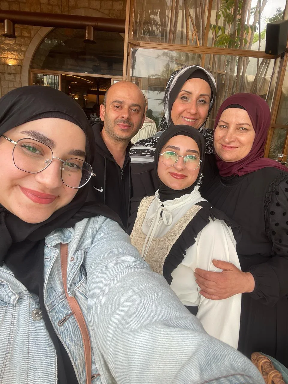 A group selfie outside a restaurant: Fatima in the middle, surrounded by four smiling faces.