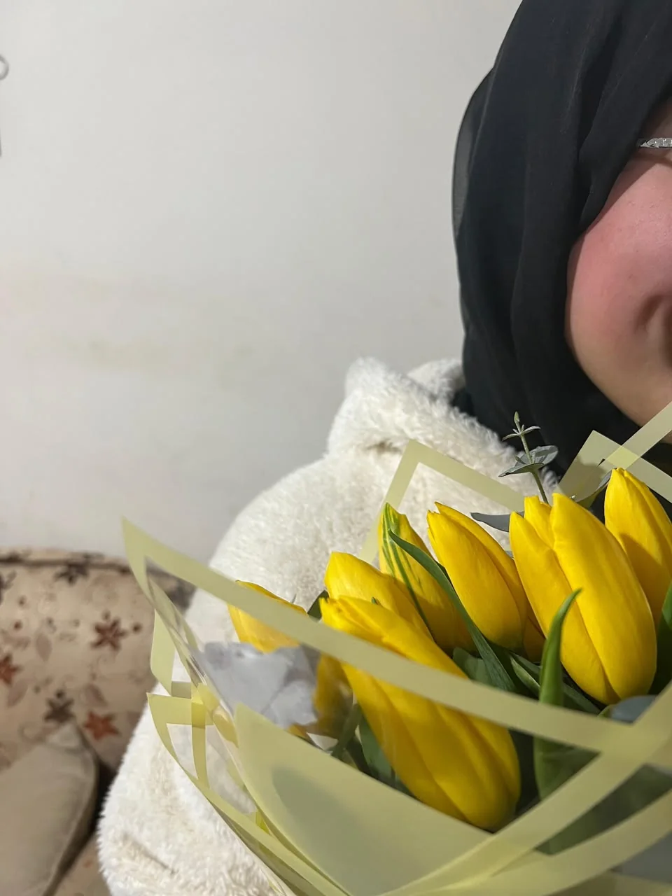 A bouquet of yellow tulips held close.